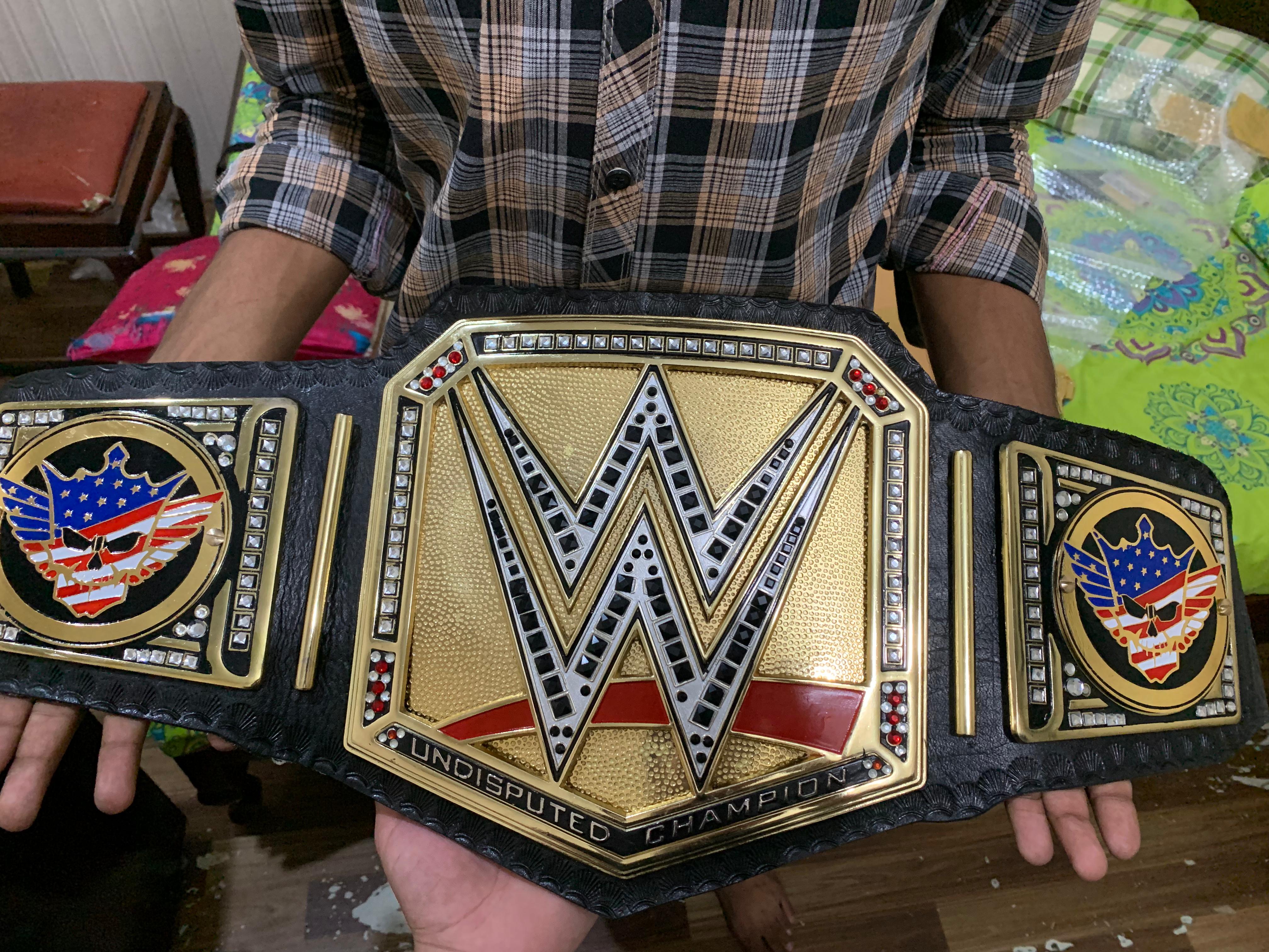 Championship belt detail — real zinc-alloy plates, real leather strap